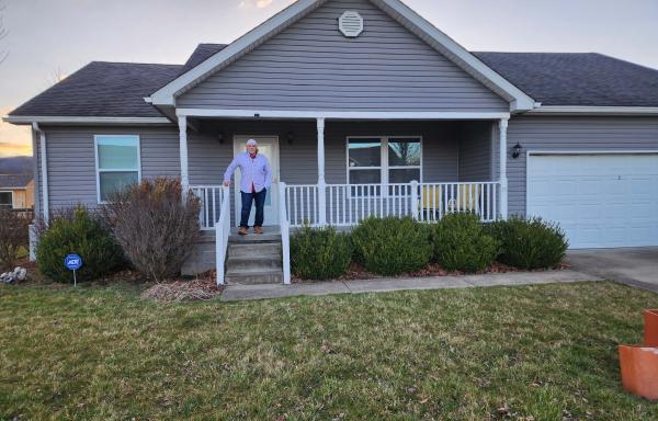 Richard Smith stands on the porch of his new home in Elkins, West Virginia.