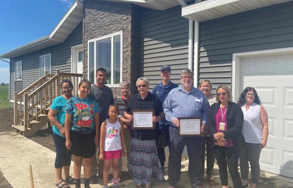 Brian and Catherine Bartunek family with Rural Development staff outside home