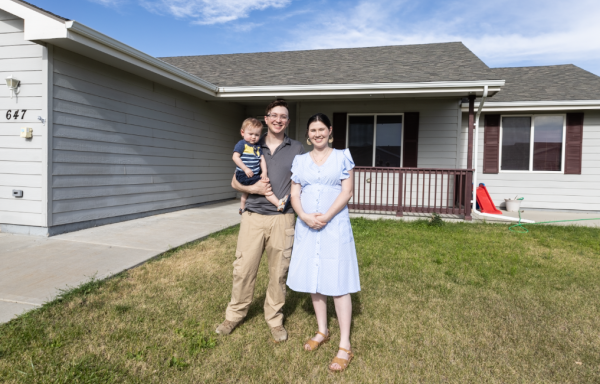 Bodee, his wife Alexandria and their young son proudly stand in front of their first home!
