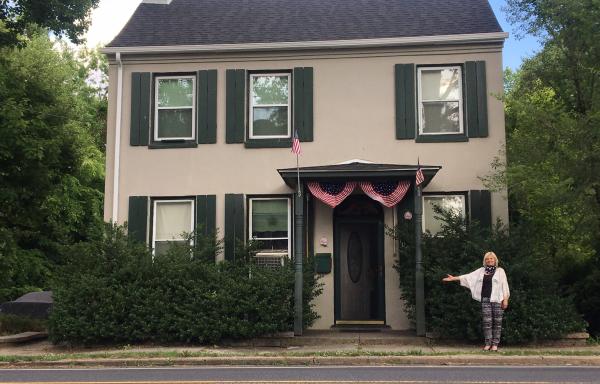 NJ resident Antonia Santos stands in front of repaired home.
