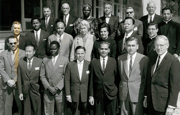 Group of adults in business suits standing on the front steps of a building. They are the 1963 coop seminar graduates of uwcc, the first class ever.