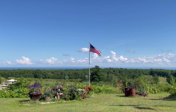 View of blue skies and Lake Superior with American flag in the middle.