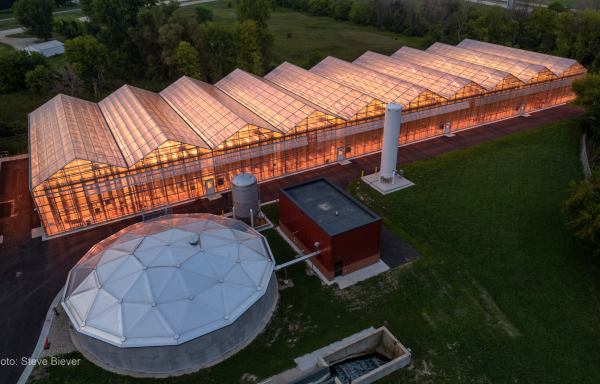 An aerial view of a glowing greenhouse at the Waupun Wastewater Treatment Facility.