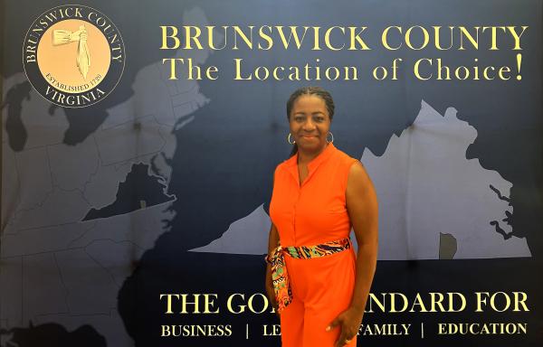 Alfreda Jarrett-Reynolds poses in front of a Brunswick banner