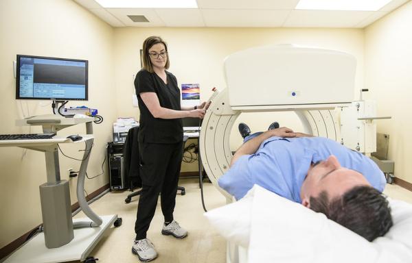 Photo of nurse using a nuclear medicine camera