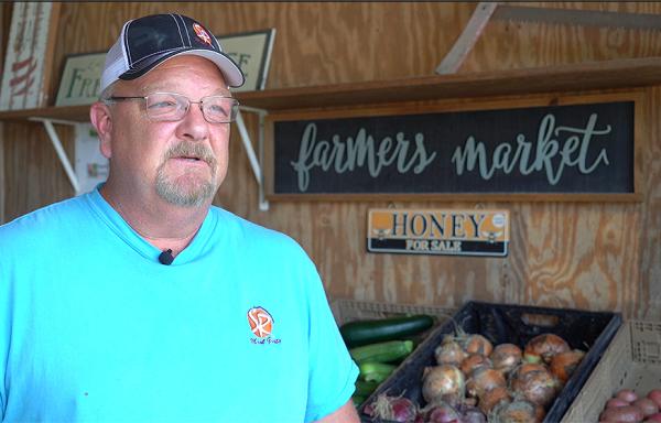 William French standing near produce in his farmers market.