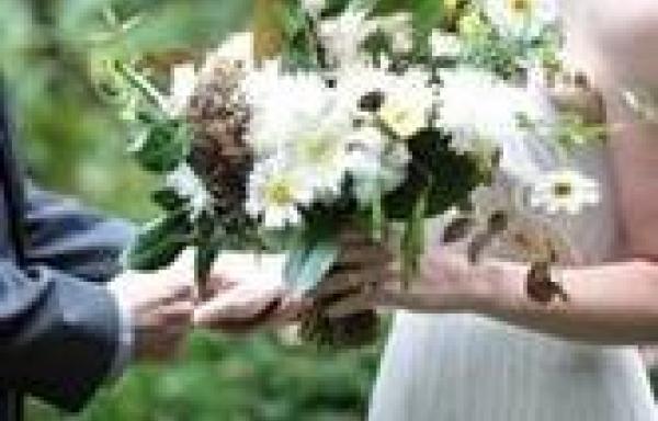 A bride holds a floral arrangement made by 3 Porch Farm, an fusion of artistic expression and natural rhythms