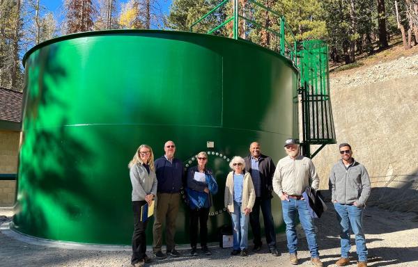 7 people standing in front of water tank