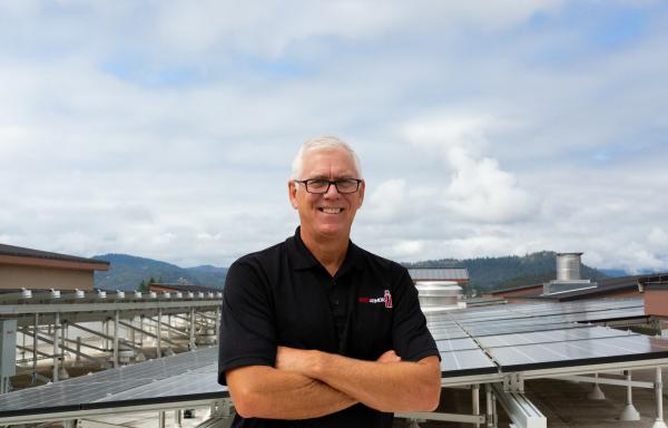 Bruce Hanna, owner of Hampton Inn and Suites Roseburg, visits solar panels recently installed on hotel roof.