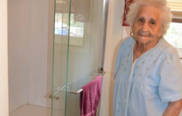 woman standing beside new shower in bathroom