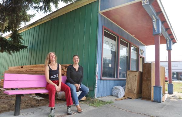 Two women sitting on a pink bench