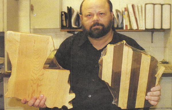 Brian Sinclair holds state shaped cutting boards