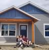 A picture of Amber and her family in front of the house they built