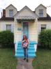 June Walker stands in front of her home.