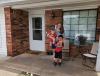 Photo of Hysell family. Sydney, Mylon, and Ghavon on front porch of their new home.